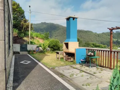 a house with a blue chimney on a balcony at Quinta do Serrado II in Ribeira da Janela