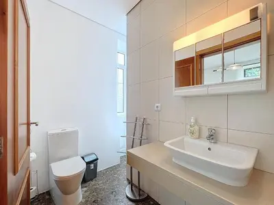 a white bathroom with a sink and a toilet at Quinta do Serrado II in Ribeira da Janela