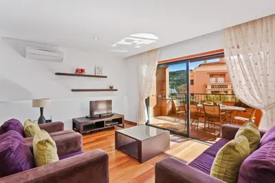 a living room with two purple couches and a balcony at Luxury Holiday 2-bedroom Apartment Praia da Luz in Luz