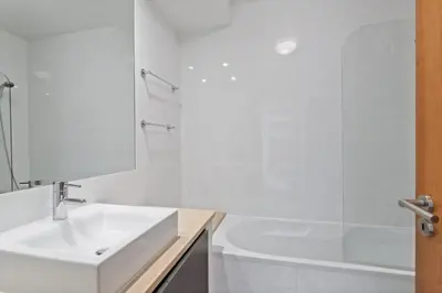 a white bathroom with a sink and a tub at Luxury Holiday 2-bedroom Apartment Praia da Luz in Luz