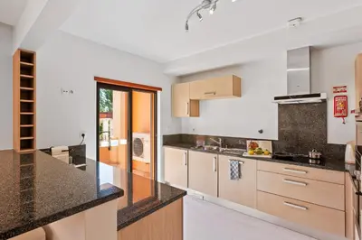 a kitchen with black counter tops and wooden cabinets at Luxury Holiday 2-bedroom Apartment Praia da Luz in Luz