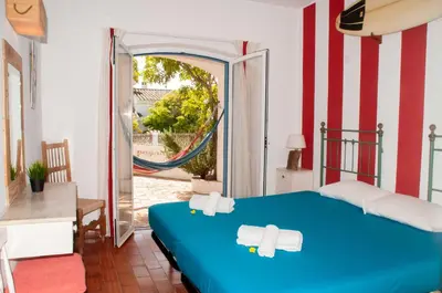 a bedroom with a blue bed with towels on it at Jho'La Surf Camp in Luz