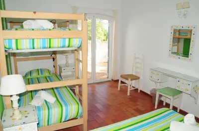 a bedroom with two bunk beds and a desk at Jho'La Surf Camp in Luz
