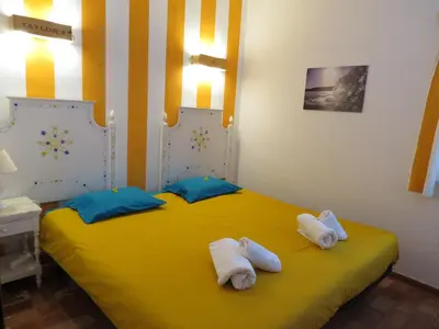 a bedroom with a yellow bed with towels on it at Jho'La Surf Camp in Luz