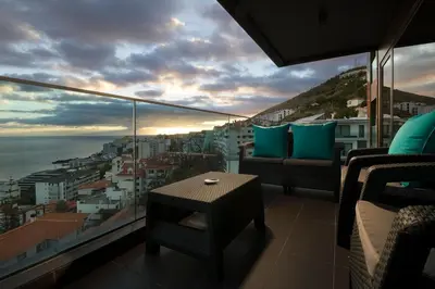 a balcony with a table and a view of the ocean at VILLA PARADISE - Modern and Sophisticated in Funchal