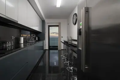 a kitchen with black counters and a clock on the wall at VILLA PARADISE - Modern and Sophisticated in Funchal