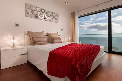 a bedroom with a bed with a view of the ocean at VILLA PARADISE - Modern and Sophisticated in Funchal