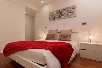 a bedroom with a large bed with a red blanket at VILLA PARADISE - Modern and Sophisticated in Funchal