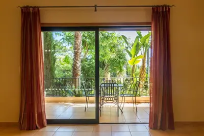 a sliding glass door with a table and chairs on a balcony at Apartamento Boa Estrela in Luz