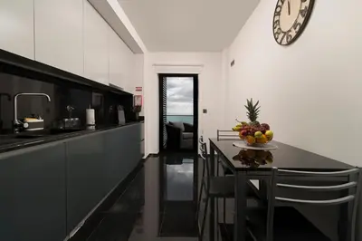 a kitchen with a table and a clock on the wall at Angel´s Paradise Luxury and Sophistication in Funchal