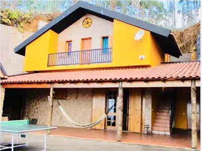 a yellow building with a ping pong table in front of it at Villa Safari Charm in Ribeira Brava