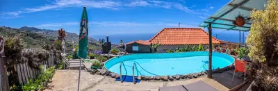 a swimming pool in front of a house at Casas Tipicas Candelaria Tabua in Ponta do Sol