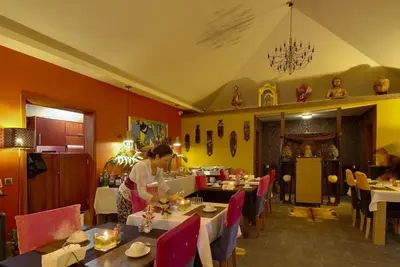 a woman sitting at a table in a restaurant at Dazk Golden Estate in Ribeira Brava