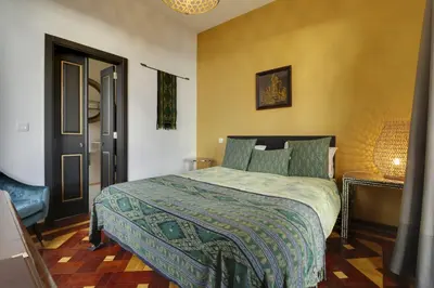 a bedroom with a bed with a green comforter at Dazk Golden Estate in Ribeira Brava