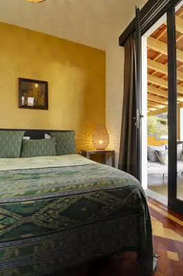 a bedroom with a bed and a sliding glass door at Dazk Golden Estate in Ribeira Brava