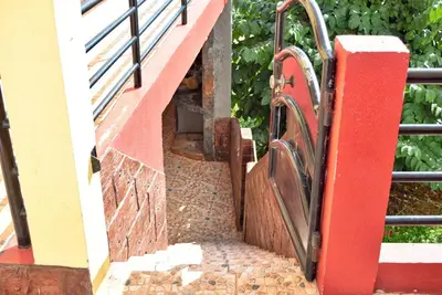 a stairway with a red railing and a red door at Vista Mar, a Home in Madeira in Ponta do Sol