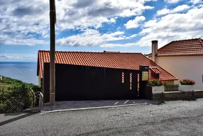 a black fence in front of a house at Vista Mar, a Home in Madeira in Ponta do Sol
