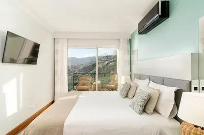a bedroom with a bed and a large window at Vila Formosa I by An Island Apart in Funchal