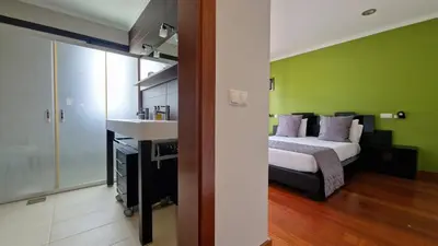 a bedroom with a bed and a green wall at Capela's House by LovelyStay in Ribeira Brava