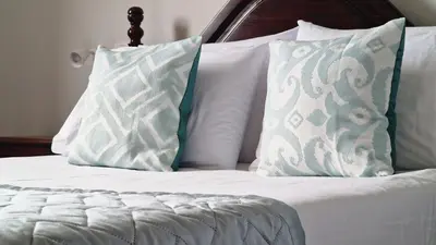 a bed with white pillows and a wooden headboard at Capela's House by LovelyStay in Ribeira Brava