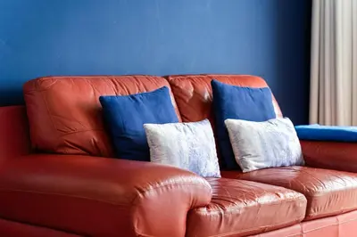 a brown leather couch with three pillows on it at Sunny Getaway in Funchal in Funchal