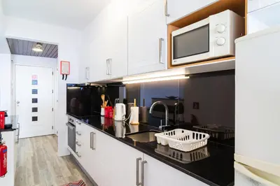 a kitchen with black counter tops and a microwave at Sunny Getaway in Funchal in Funchal