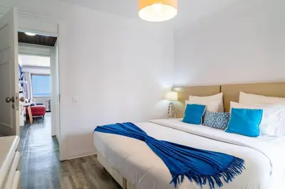 a bedroom with a large bed with blue pillows at Sunny Getaway in Funchal in Funchal