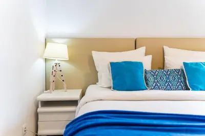 a bedroom with a bed with blue and white pillows at Sunny Getaway in Funchal in Funchal