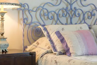 a bed with a metal headboard with a pillow and a table at CASA DA LEVADA in Funchal