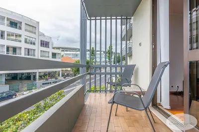 a balcony with two chairs and a table at Condo Magnolia in Funchal