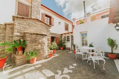 a patio with a table and chairs in front of a building at Villa Matta by Amazing Madeira in Santana