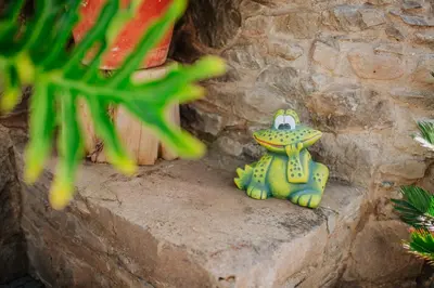 a frog figurine sitting on a stone wall at Villa Matta by Amazing Madeira in Santana