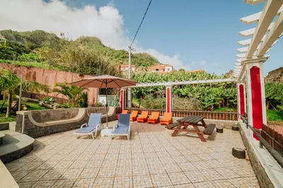 a patio with chairs and a table and an umbrella at Villa Matta by Amazing Madeira in Santana
