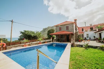a villa with a swimming pool in front of a house at Villa Matta by Amazing Madeira in Santana
