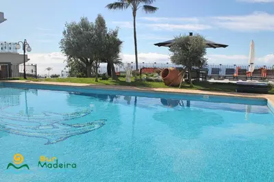 a large swimming pool at a resort with the ocean in the background at OurMadeira - BelAir in Funchal