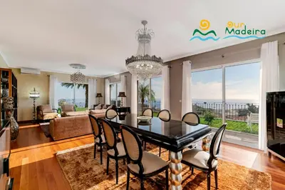 a dining room and living room with a table and chairs at OurMadeira - BelAir in Funchal