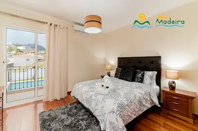 a bedroom with a bed and a balcony at OurMadeira - BelAir in Funchal