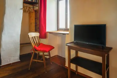 a room with a television and a desk with a chair at Madeira-Meerblick-Haus in Estreito da Calheta