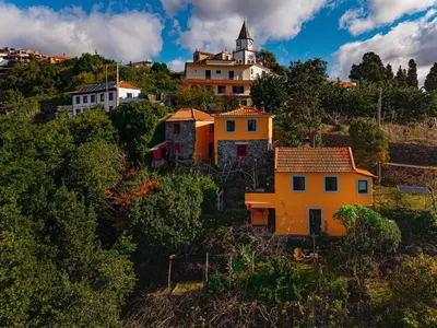 a group of houses on a hill with a church at Madeira-Meerblick-Haus in Estreito da Calheta