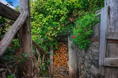 a stone wall with flowers and a wooden fence at Madeira-Meerblick-Haus in Estreito da Calheta