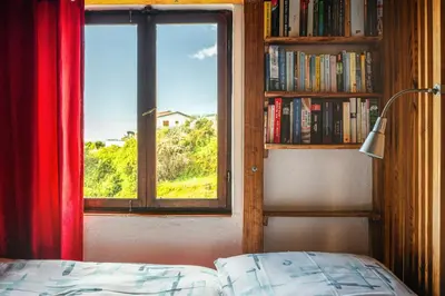a bedroom with a window and a bed and a book shelf at Madeira-Meerblick-Haus in Estreito da Calheta