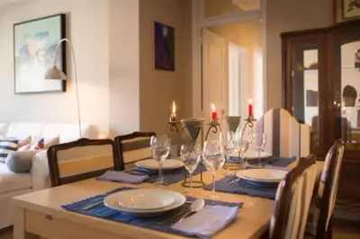 a dining room table with plates and wine glasses at Peaceful Top Floor Apt W Balconies - Cambridge RIGHT - AC in Funchal