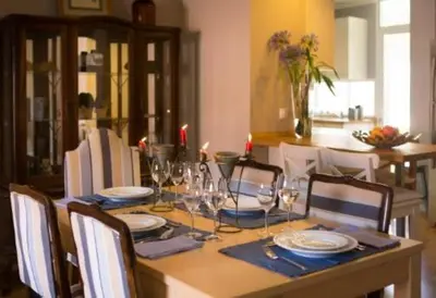 a dining room table with plates and wine glasses at Peaceful Top Floor Apt W Balconies - Cambridge RIGHT - AC in Funchal