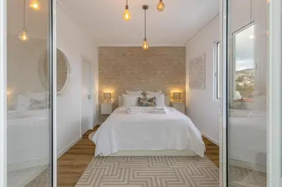 a bedroom with a white bed and glass walls at Little Townhouse Funchal in Funchal
