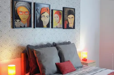 a bedroom with a bed with four pictures on the wall at Apartamento Quinta do Faial in Funchal