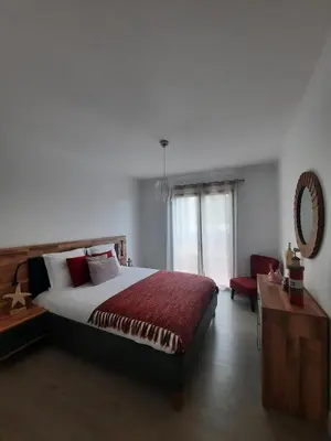 a bedroom with a bed and a table and a mirror at Casa Gama in Ribeira Brava