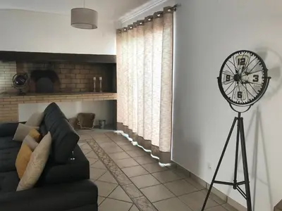a living room with a black couch and a fan at Casa Gama in Ribeira Brava