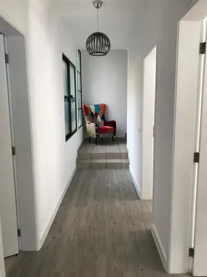 a hallway with a red chair and white walls at Casa Gama in Ribeira Brava