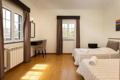 a hotel room with two beds and a desk at A Casa do Lagar in São Jorge