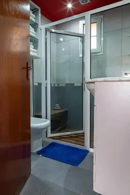 a bathroom with a toilet and a glass shower at Casa da Maria 15 - Funchal - Famílias in Funchal